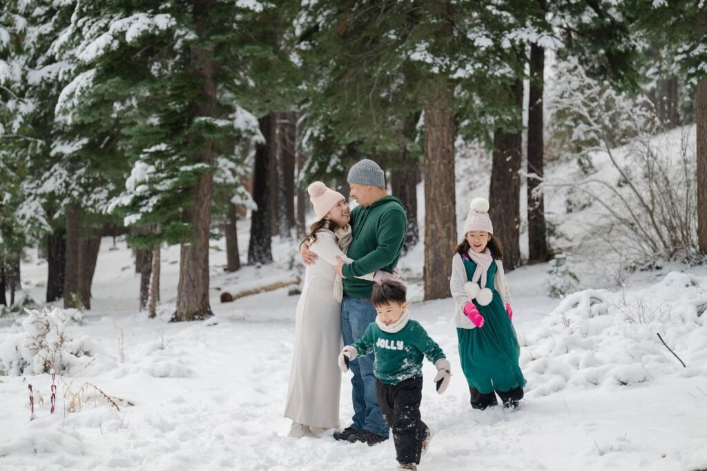 family portrait with toddler running circles during winter session in Northstar