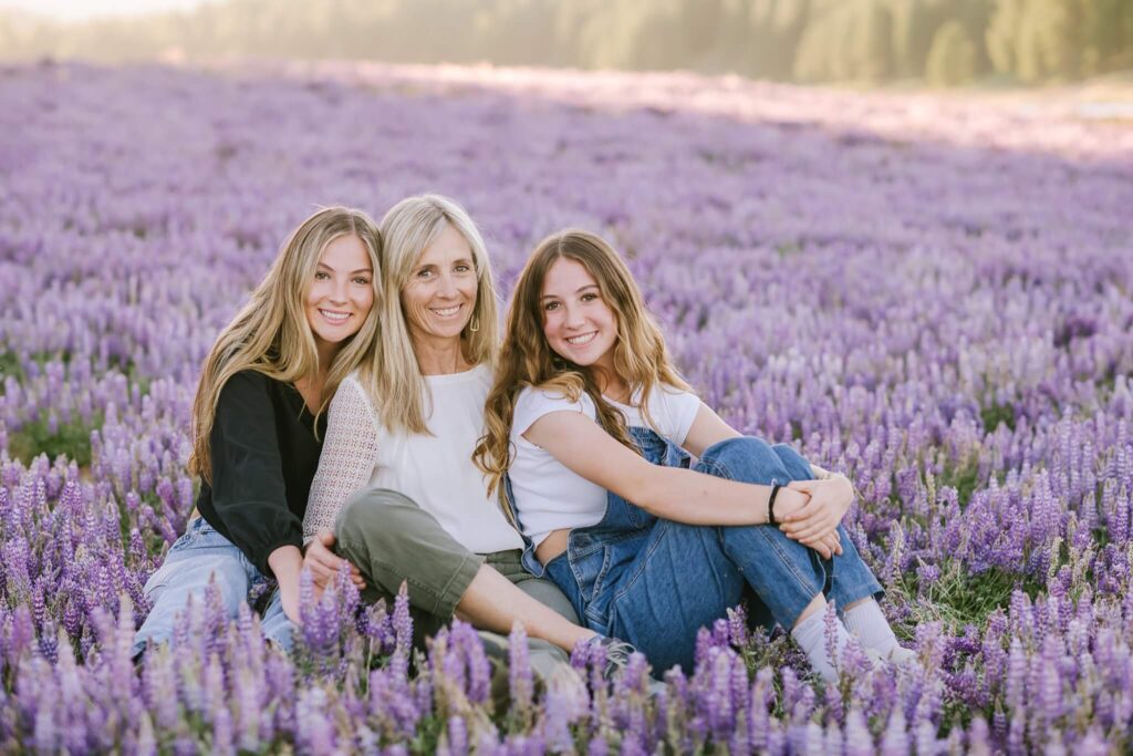 Mother and girls in a field of Lupines during a summer portrait session captured by Truckee family photographer Annie X Photographer