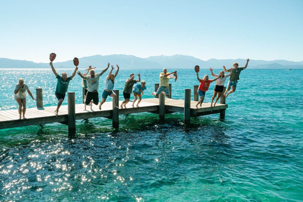 Big family jumping off dock in Lake Tahoe