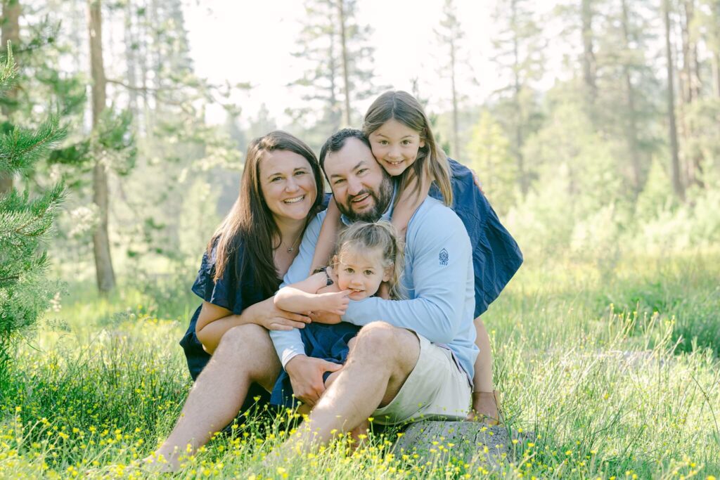 family sitting in north lake tahoe meadow showing wildflowers