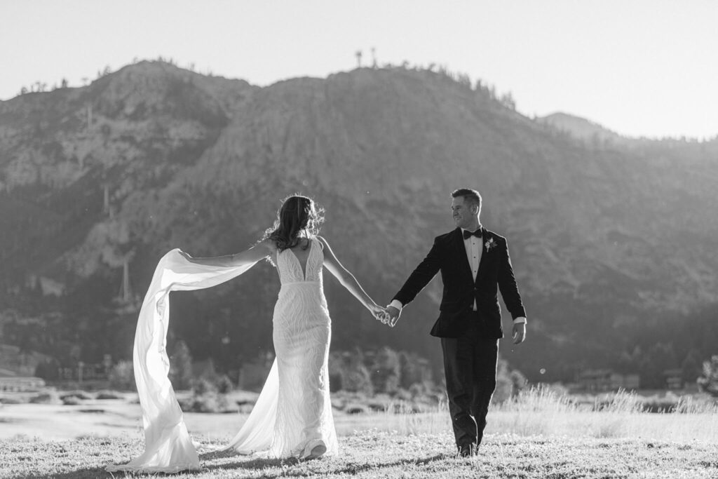 Bride and Groom black and white image of them walking towards camera with Palisades in the back photographed by Annie X