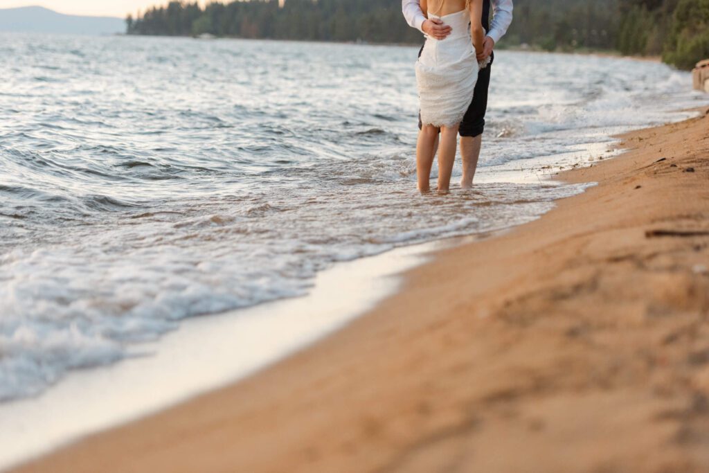 Bride and groom feet only on a private sandy beach at sunset in Lake Tahoe