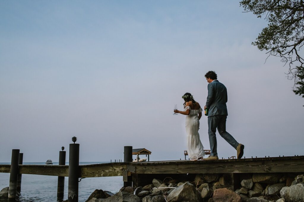 Bride and Groom walking towards their boat for a champagne toast during an intimate wedding at Lake Tahoe at private residence