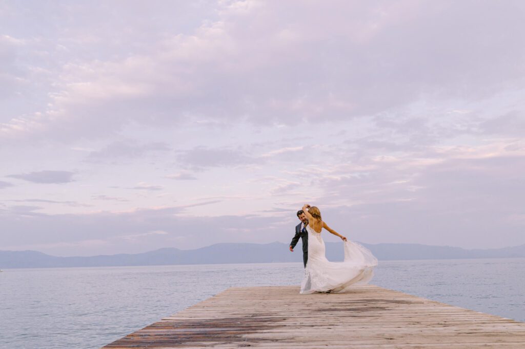 Cotton candy skies with bride and groom on the pier of Valhalla at sunset captured by Annie X