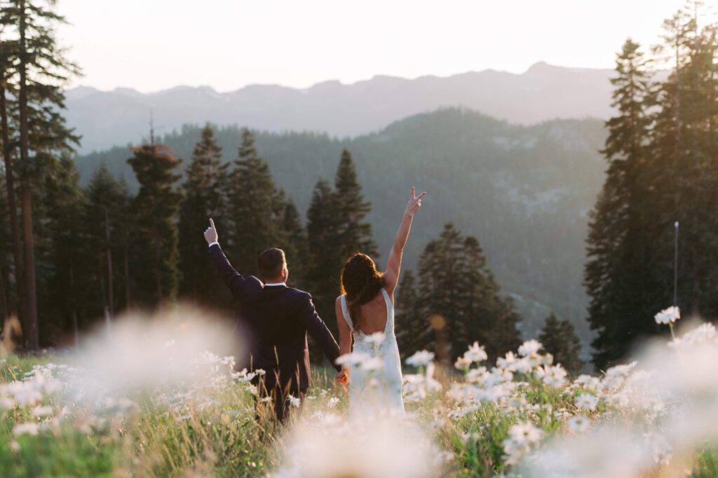 Bride and Groom hands in the air in a field of daisies at Northstar Tahoe