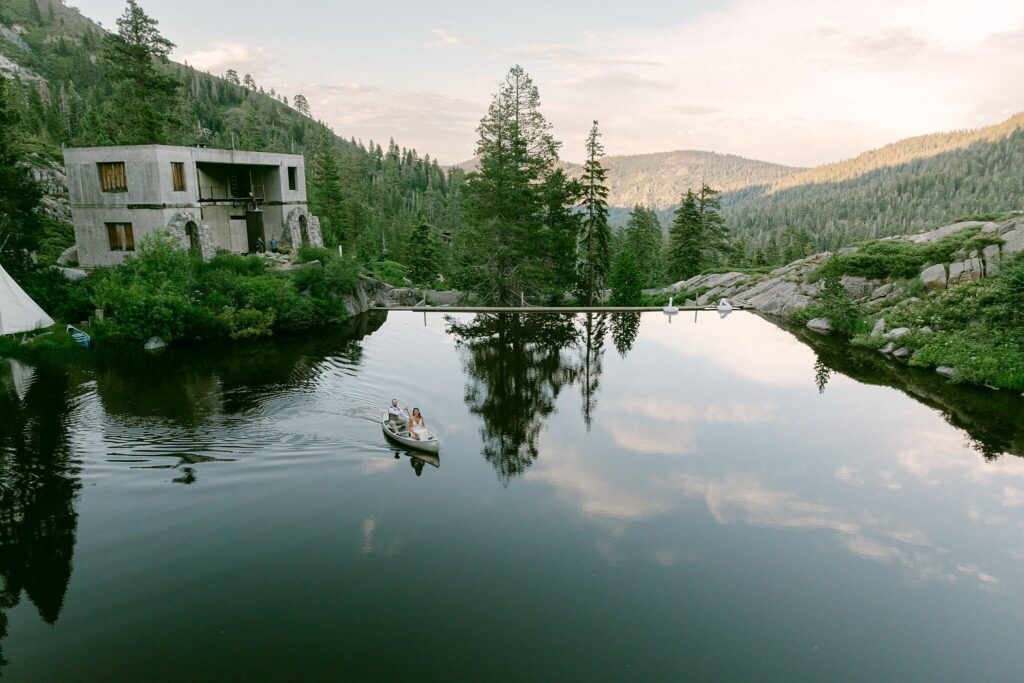 Overview of White Wolf Tahoe wedding while bride and groom taking a lap in a canoe at golden hour