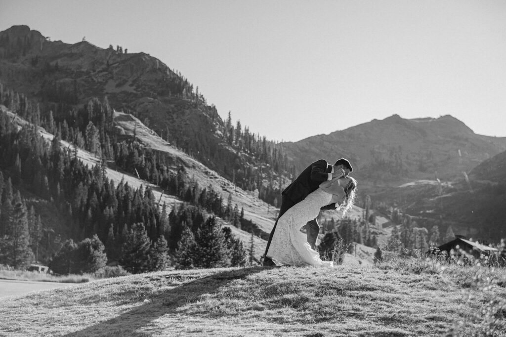 bride nad groom during portraits in teh olympic valley with Palisades Tahoe in the backdrop black and white image