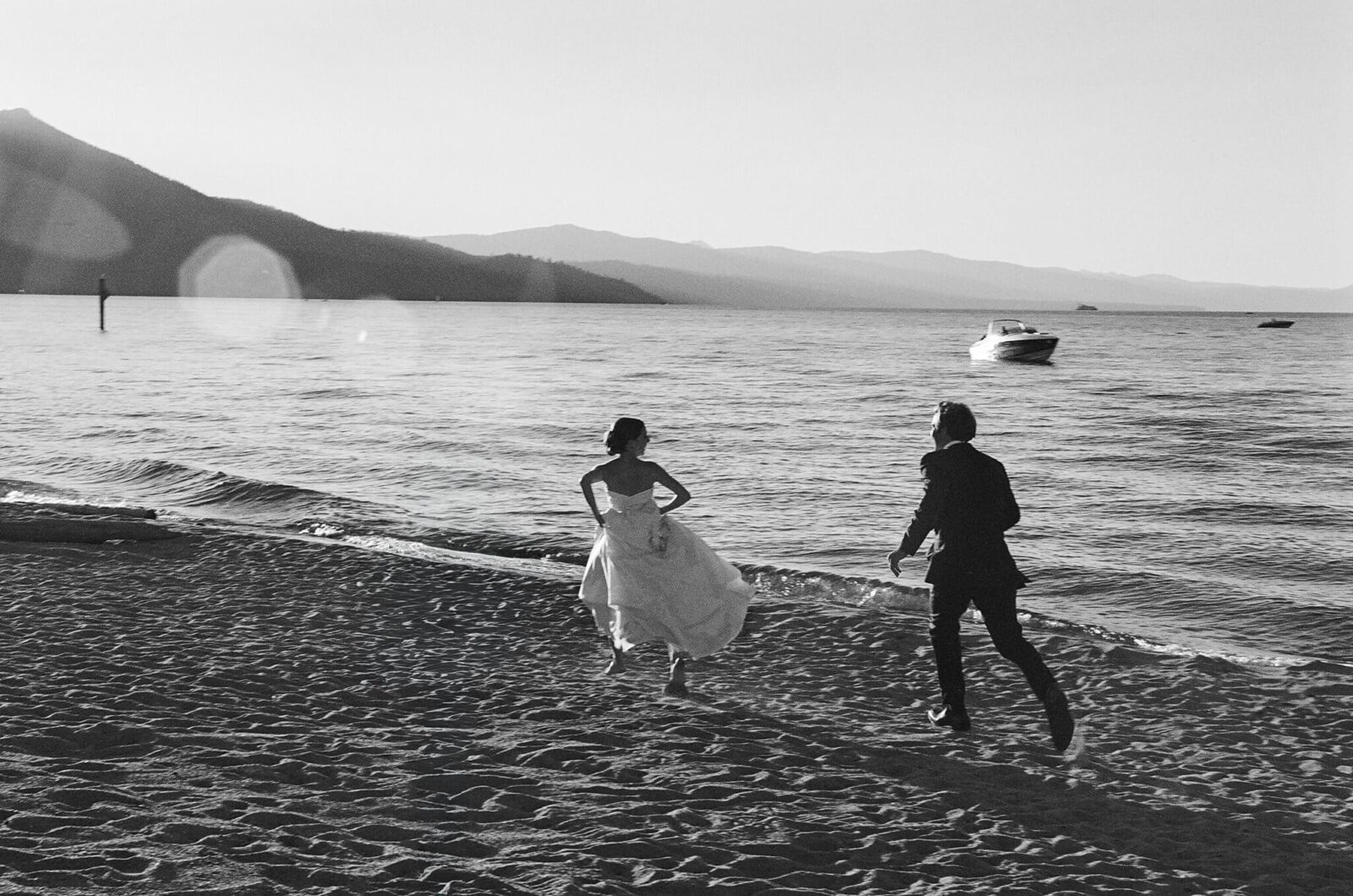 Tahoe Keys bride and groom running on beach photographed by Annie X Photographie