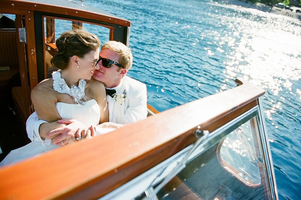 groom huggin his bride on vintage boat after getting married at their private lake Tahoe estate