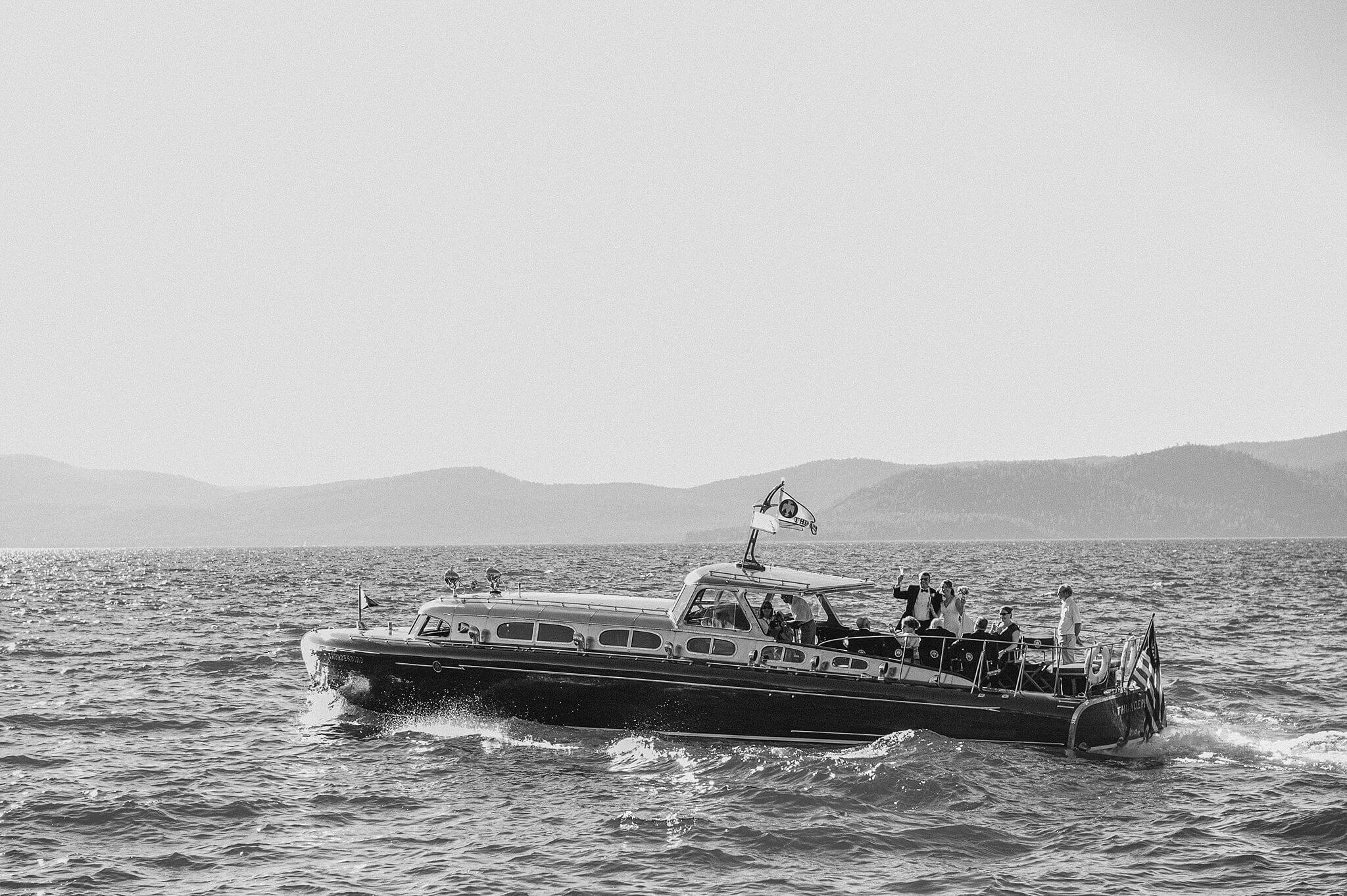 Exclusive Lake Tahoe wedding venues and a Wedding party during cocktail hour on the prestigious Thunderbird vintage boat captured by Annie X Photographie on Lake Tahoe