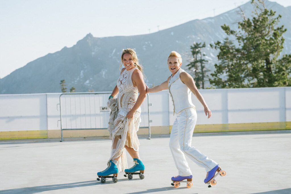 two brides rollerskating at their wedding during cocktail hour up at High Camp at Palisades Tahoe