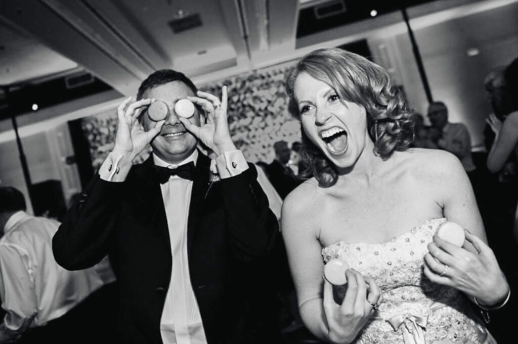 Bride and Groom playful with macarons during their reception captured by Tahoe wedding photographer Annie X