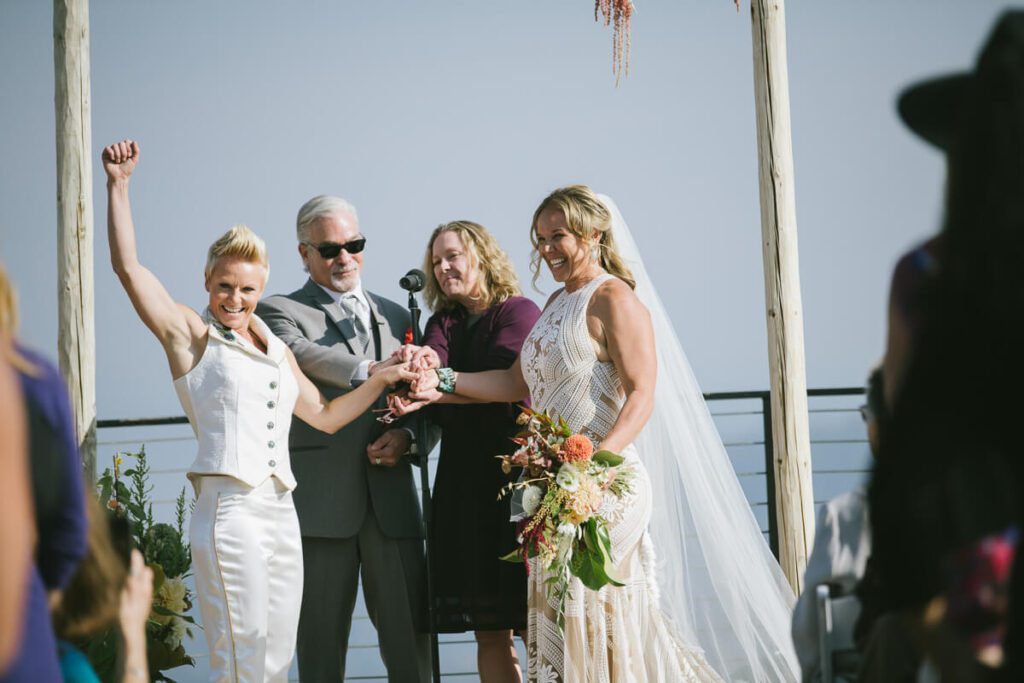 fist pumps and high fives and huge smiles for these two brides at their ceremony at Palisades Tahoe High Camp