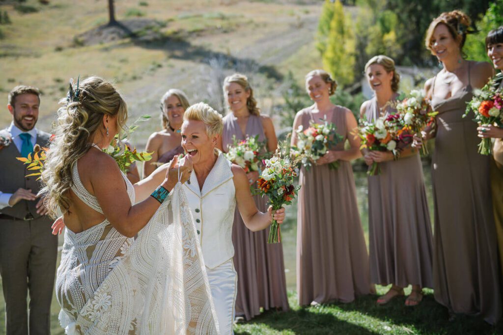 Two brides first look reactions photographed by Palisades Tahoe wedding photographer Annie X during a fall wedding