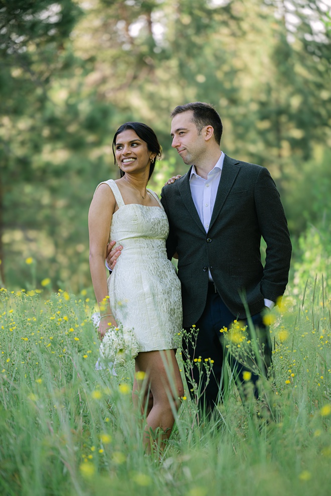 Bride and Groom in meadow looking away from camera