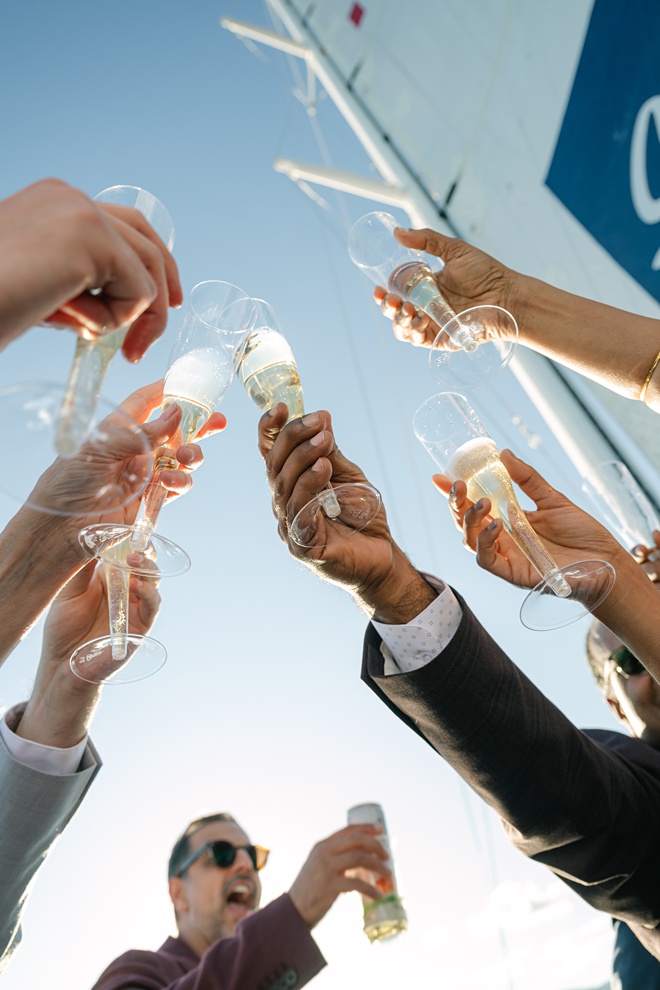 Family toasting during Sierra Cloud catamaran wedding sail champagne flutes close up
