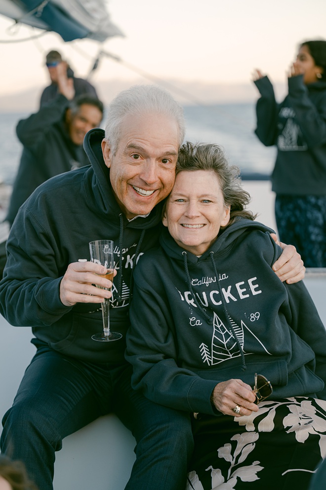 Parents enjoying the champagne and sunset during this Tahoe boat wedding