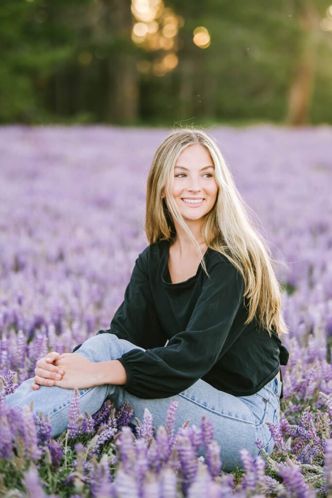Senior photos of Truckee senior girl sitting in wild flowers captured by senior photographer Annie X Photographie