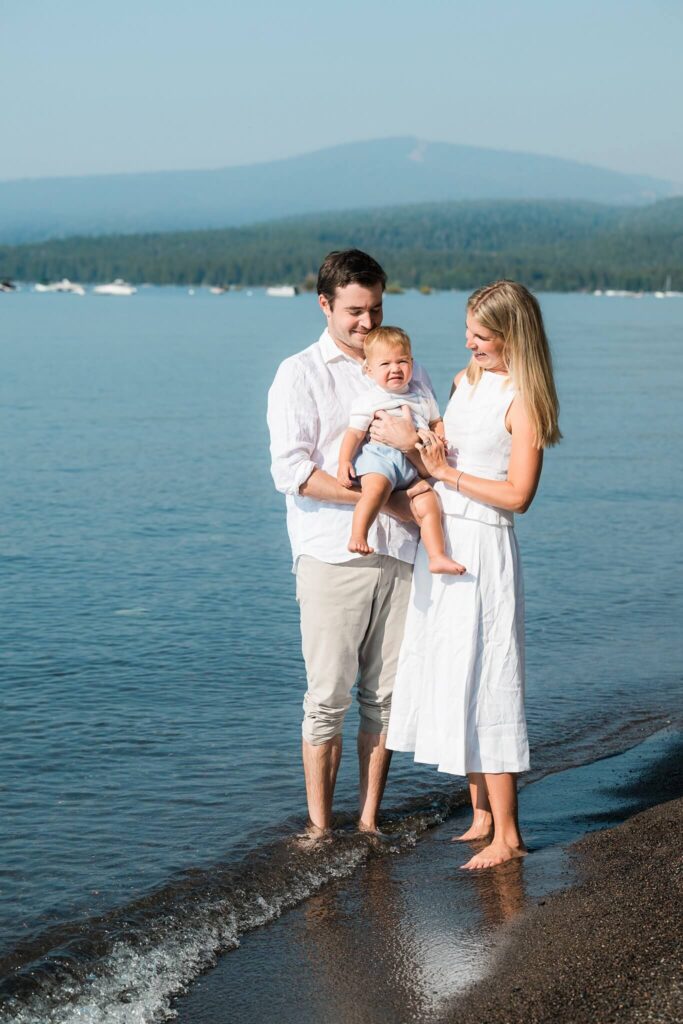 Tahoe family photorgapher capturing baby and parents on beach on a summer morning