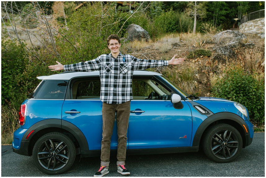 Senior photos in Tahoe with personality, senior boy showing his arm span as same size his mini Cooper in Palisades Tahoe