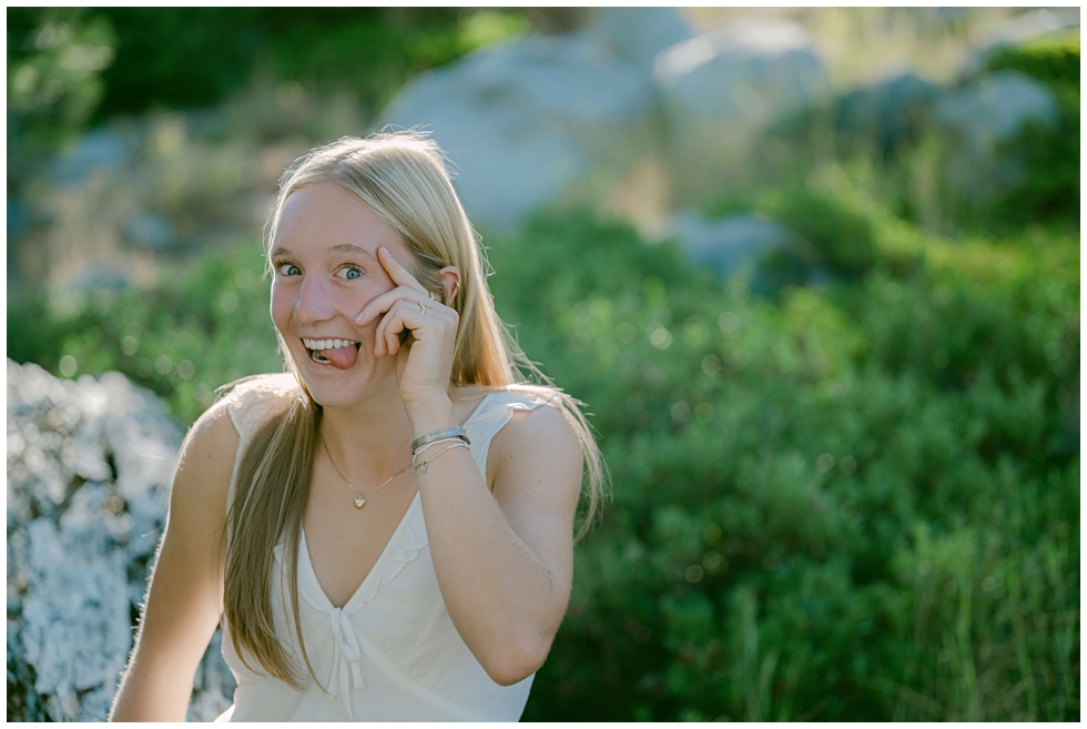 Senior girl with blue eyes being silly in soft mountain light at Palisades Tahoe
