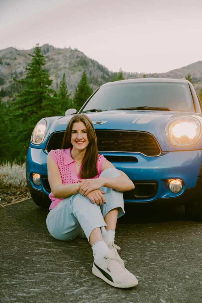 Lake Tahoe senior sitting in front of her family mini Cooper for Tahoe senior photos