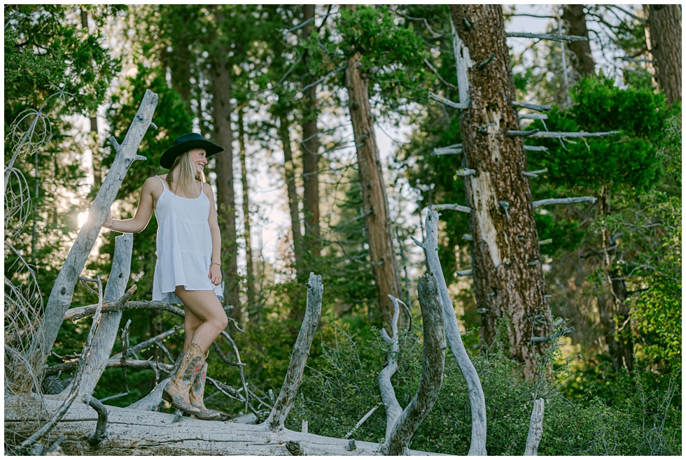 Tahoe senior portraits of Senior girl in cowgirl hat standing among tall pines at Sugar Pine Point