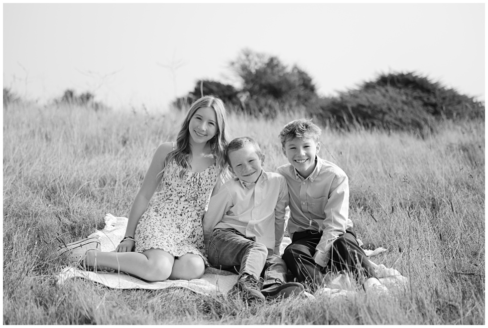 black and white portrait of the kids sitting in tall gras in Sausalito photographed by Marin family photographer
