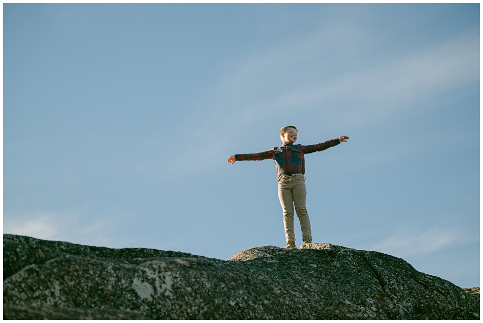 Truckee family photos of a boy standing on a granite boulder during a Tahoe family portrait session