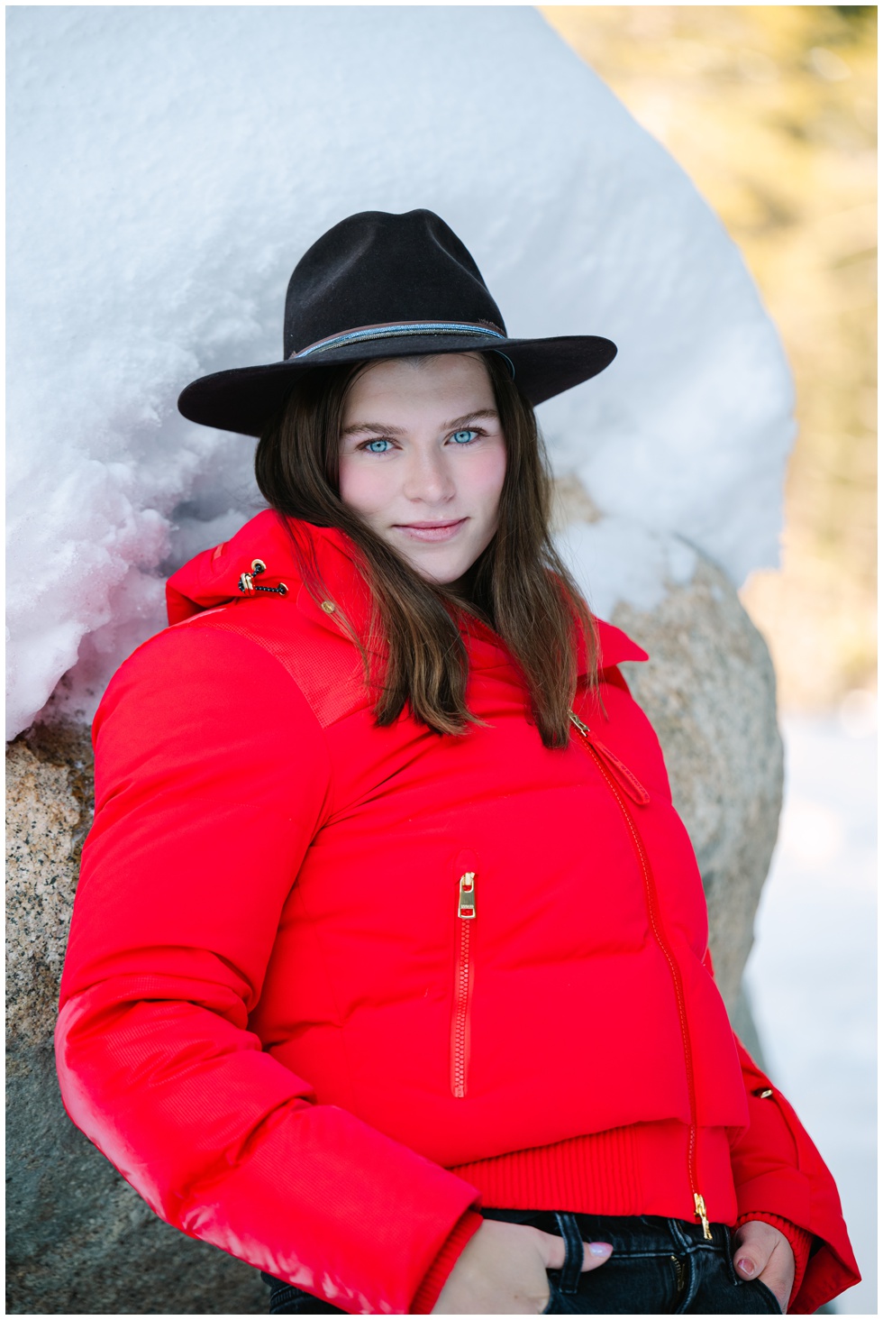 Truckee family photographer capturing this girl with red winter jacket and cowboy hat plus piercing blue eyes during a family session for their Valentine's day card