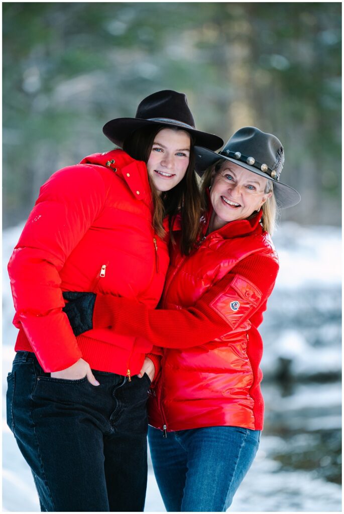 Mom and daughter hugging and laughing during winter truckee family photos wearing red