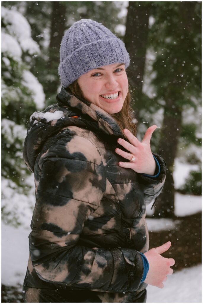 engagement proposal session in the snow with bride to be showing her ring off