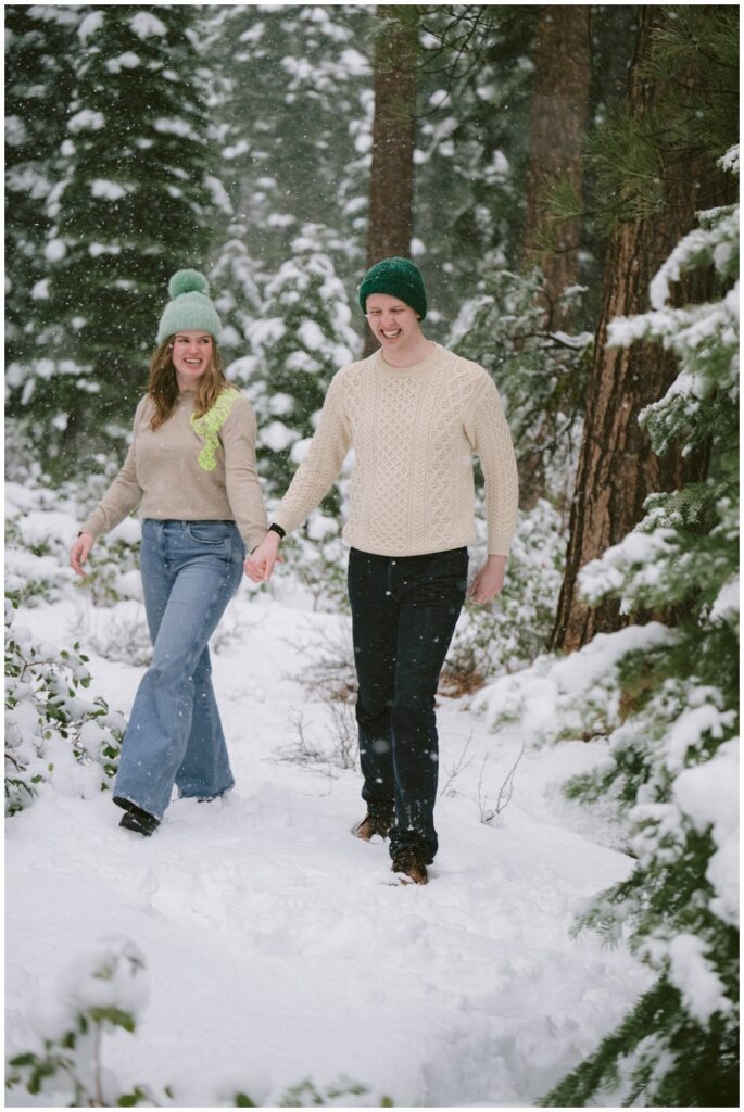 couple walking in a snow field amongst Tahoe pines