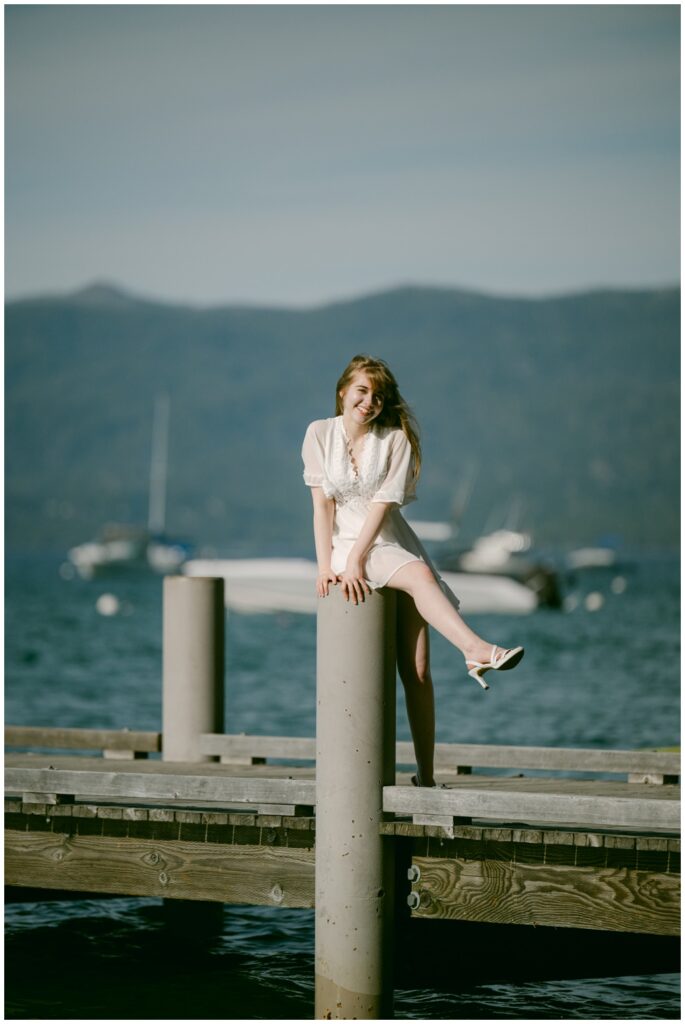 Senior sitting on a dock piling with sailboats in the background, Valhalla South Lake Tahoe