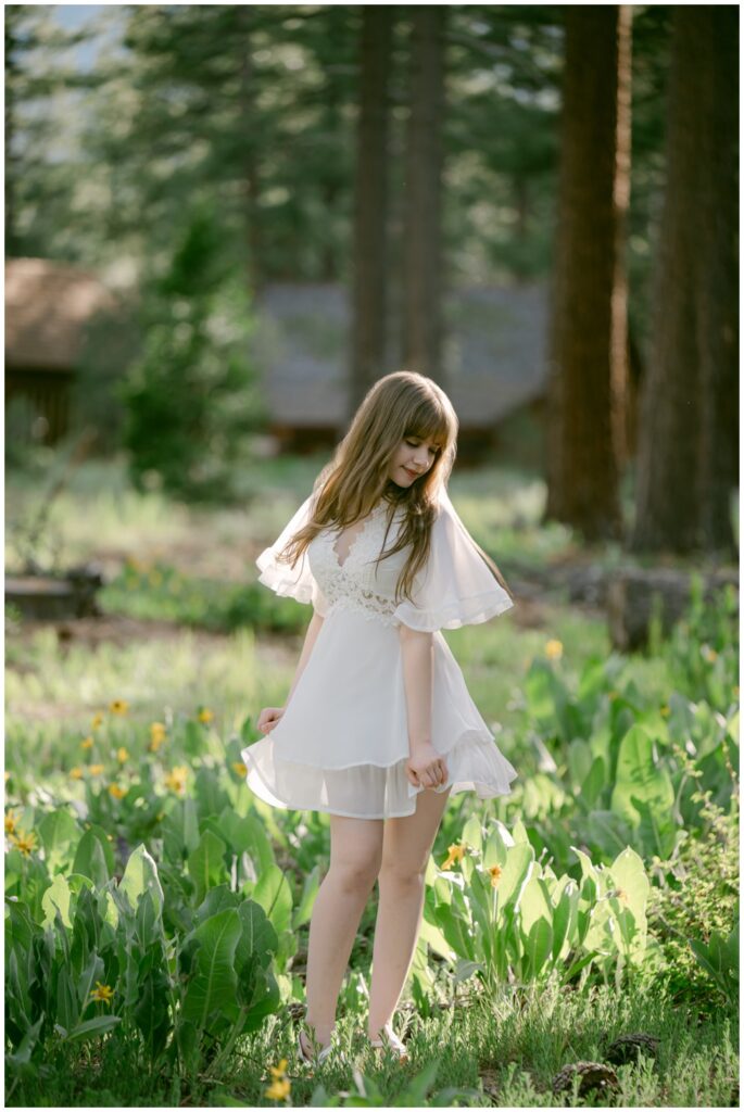 Senior in a white dress walking through wildflowers at Valhalla, South Lake Tahoe