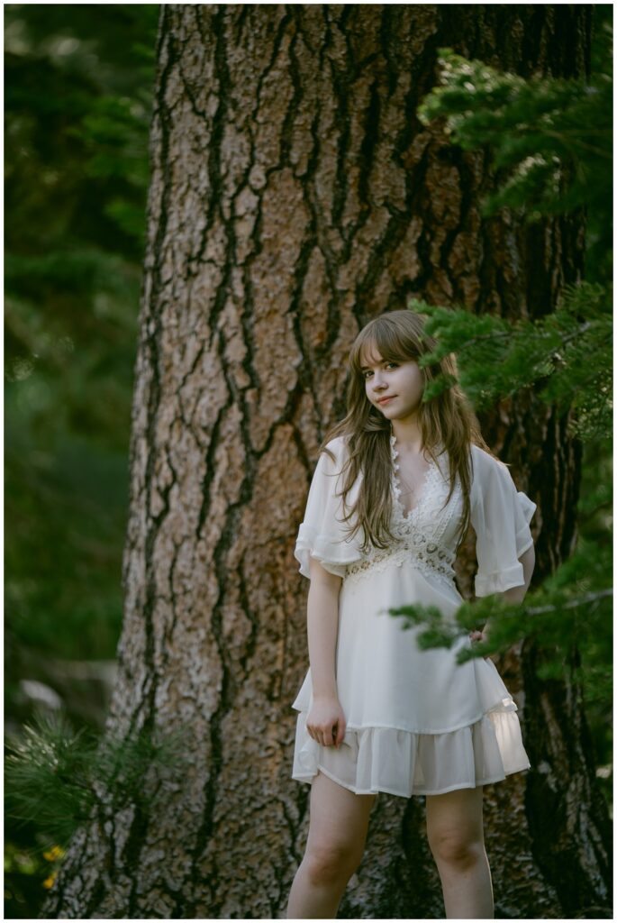 Senior standing by pine trees in a white dress, Valhalla South Lake Tahoe
