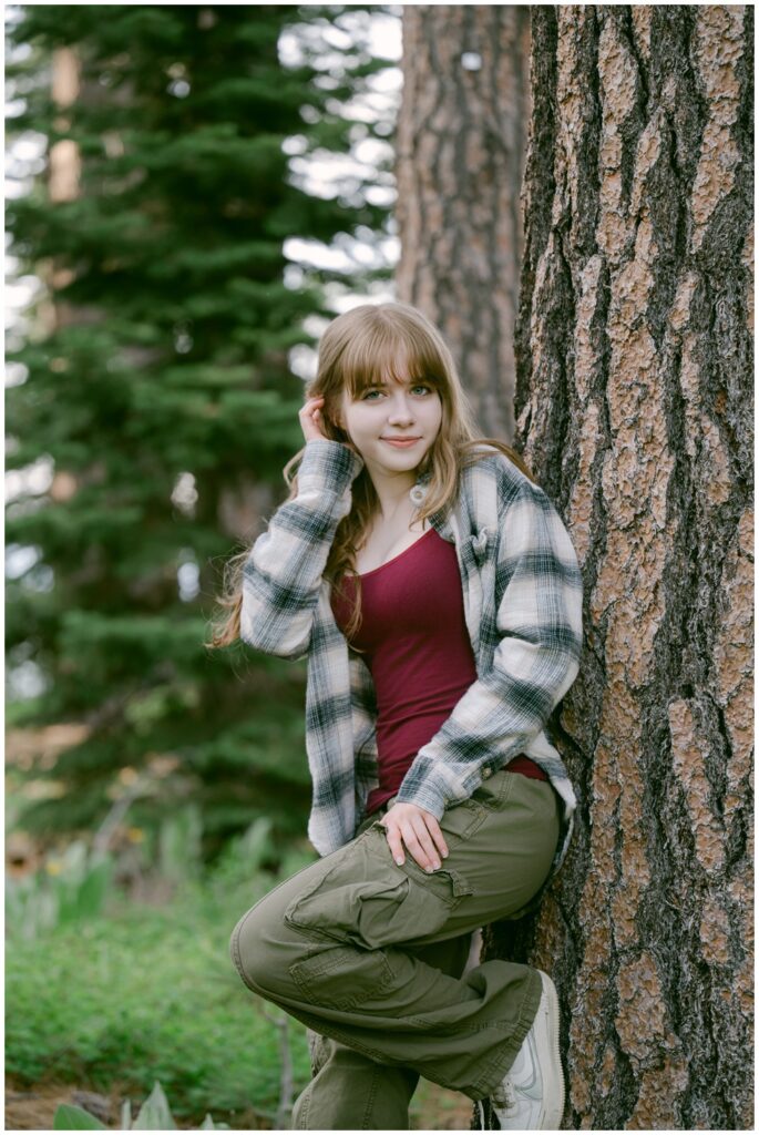 Senior in a plaid shirt leaning against a pine tree, Valhalla South Lake Tahoe