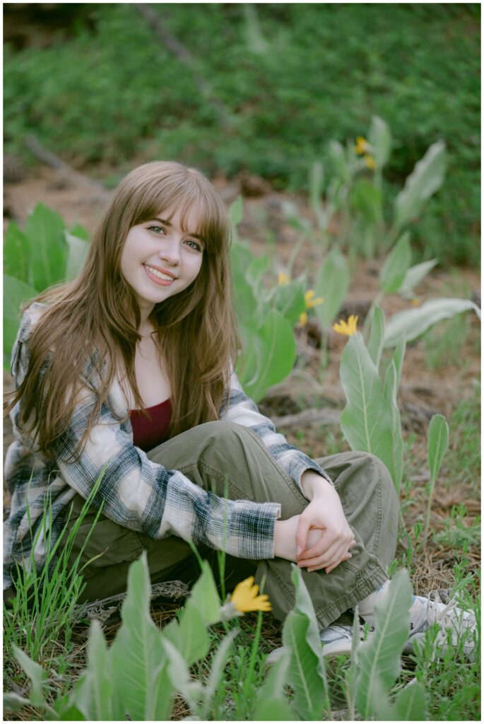 Senior in casual plaid and jeans sitting among Tahoe wildflowers, Valhalla South Lake Tahoe