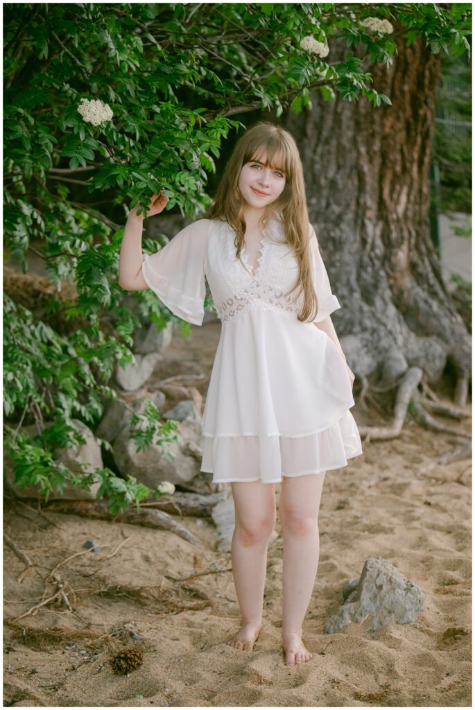 Tahoe senior photographer capturing full length senior portrait in a white dress in South lake Tahoe
