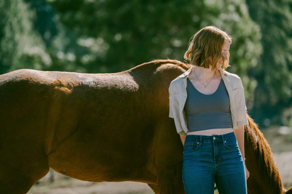 side view of face of senior girl elaning on her horse during portrait session