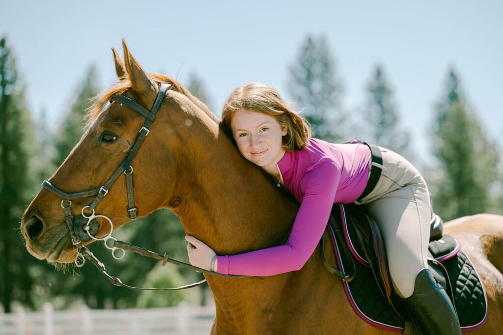 senior girl and her horse in dressage wear pink top