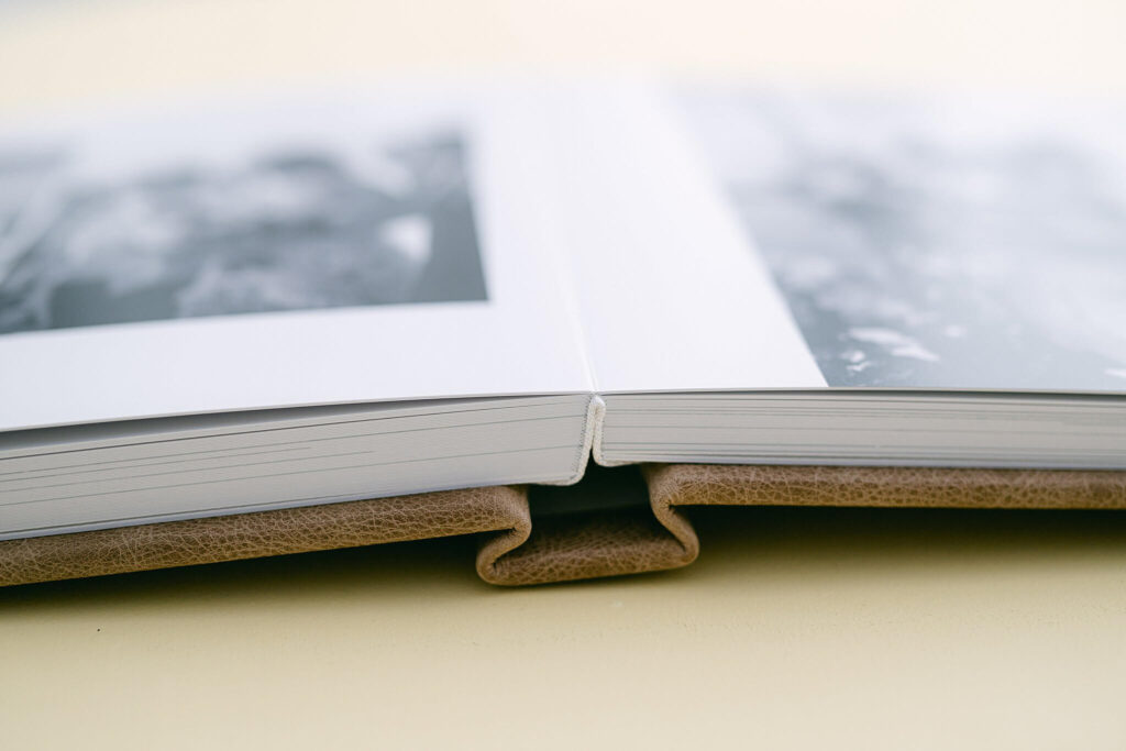 wedding album open showing layflat spread and spine of leather cover of redtree albums